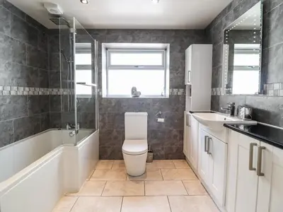 a bathroom with a toilet and a tub and a sink at Llys Tirion in Bala