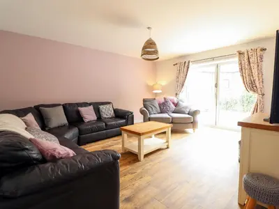 a living room with a couch and a table at Llys Tirion in Bala