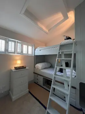 a bedroom with a ladder and a bunk bed at Efail Fach in New Quay