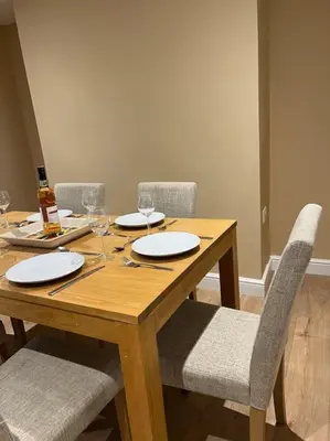 a wooden table with chairs and plates and wine glasses at Beautiful mid wales cottage in Garth