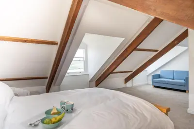 a bedroom with a bed with a bowl of fruit on it at Loyalty in New Quay