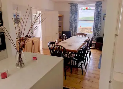 a kitchen and dining room with a table and chairs at Loyalty in New Quay