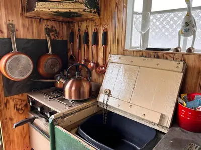 a kitchen with a stove with a tea kettle and utensils at Ty Gwenyn, Coity Bach in Brecon