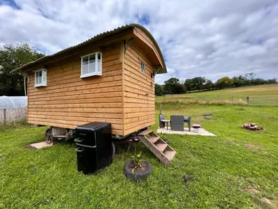 a small wooden house sitting in the grass at Ty Gwenyn, Coity Bach in Brecon