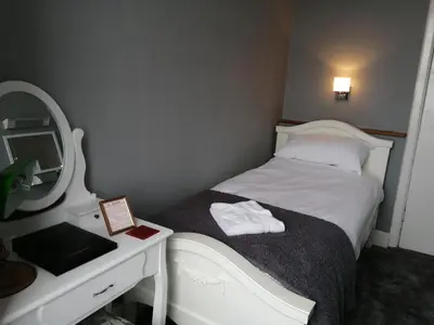 a small bedroom with a bed and a mirror at Wavecrest in Barmouth