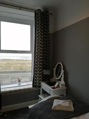 a bedroom with a bed and a large window at Wavecrest in Barmouth