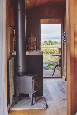 a wood stove in a room with a doorway at Big Sky Hideaway in Leominster