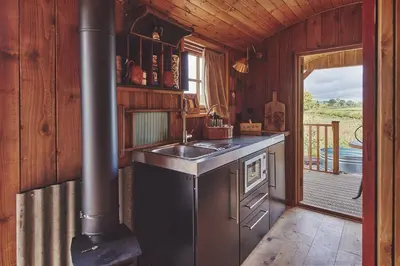a kitchen with a sink and a stove in a cabin at Big Sky Hideaway in Leominster