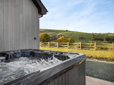 a hot tub on the side of a building with water at The Lara - Uk45019 in Mochdre