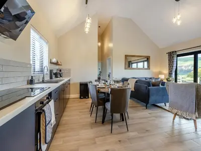 a kitchen and living room with a table and a couch at The Lara - Uk45019 in Mochdre