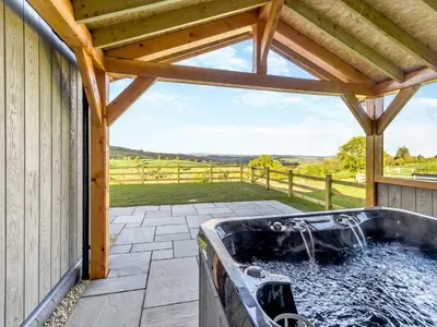 a hot tub on a patio with a view at The Warne - Uk45018 in Mochdre