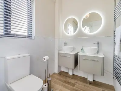 a white bathroom with two sinks and mirrors at The Warne - Uk45018 in Mochdre