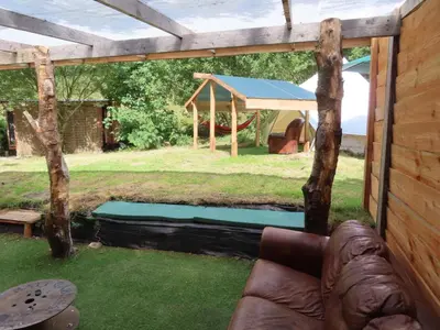 a backyard pool with a gazebo and a trampoline at Dingly Dell 3 x bell tents in Cemmaes