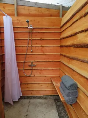 a bathroom with a shower with a bench and a towel at Dingly Dell 3 x bell tents in Cemmaes