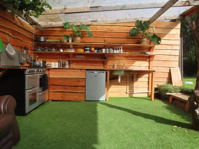an outdoor kitchen with a table and a stove at Dingly Dell 3 x bell tents in Cemmaes