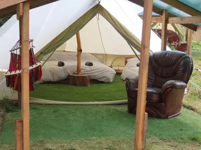 a leather chair sitting in front of a tent at Dingly Dell 3 x bell tents in Cemmaes