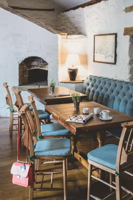 a dining room with a table and chairs and a fireplace at The Clive Arms in Ludlow