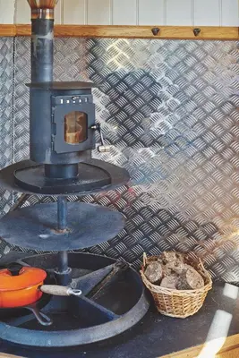 a stove sitting next to a basket and a wall at Curious Calf in Leominster