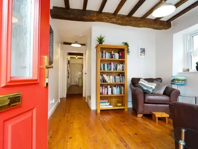 a living room with a couch and a book shelf at Characterful 3 Bedroom Cottage in Aberystwyth