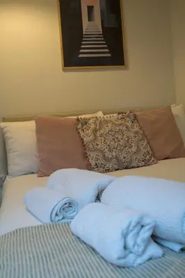 a bed with two towels on it with a picture at Relaxing Town Centre House - Perfect for Exploring in Shrewsbury