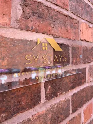 a house sign on the side of a brick wall at Relaxing Town Centre House - Perfect for Exploring in Shrewsbury