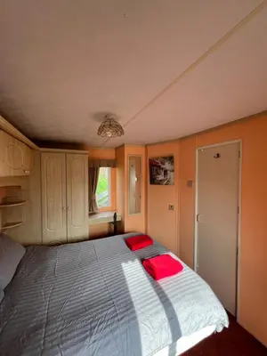 a bedroom with a bed with red pillows on it at Holiday Home by the sea in Aberystwyth