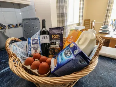 a basket filled with food and wine on a table at Hillside Lodge in Llandrindod Wells
