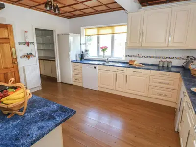 a kitchen with white cabinets and a blue counter top at Hillside Lodge in Llandrindod Wells