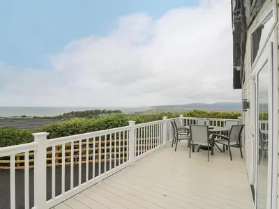 a balcony with a table and chairs on it at Platinum Lodge in Borth