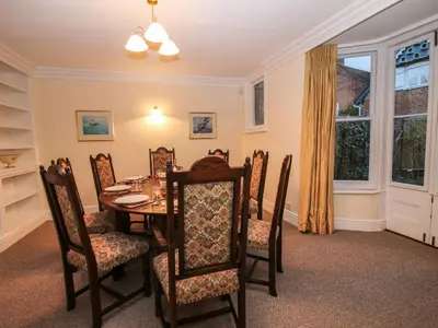 a dining room with a table and chairs and a window at Dinham Court in Ludlow