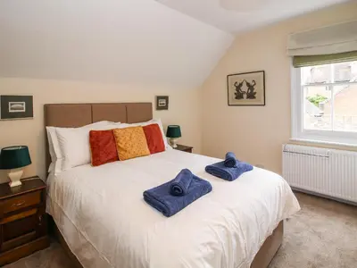 a bedroom with a large white bed with towels on it at Dinham Court in Ludlow
