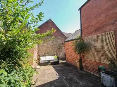an alley with a white couch in a brick building at Dinham Court in Ludlow