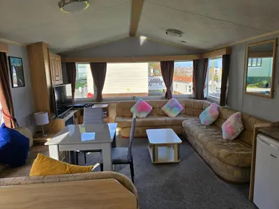 a living room with a couch and a tv at Light and Airy 2 Bedroom Mobile Home in Aberystwyth