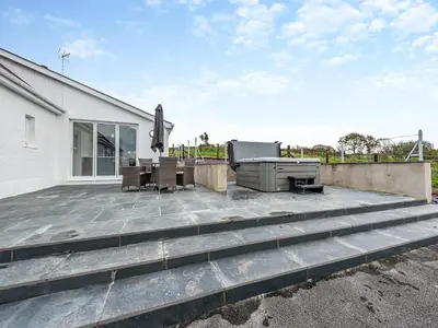 a patio with a table and chairs and a building at Maesyrhaf in Llanllwchaiarn