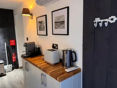 a kitchen counter with a coffee maker and a microwave at Penestaer in Machynlleth