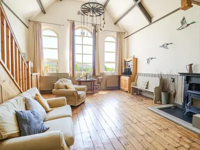 a living room with a couch and a fireplace at St Marks School House in Llanwrthwl