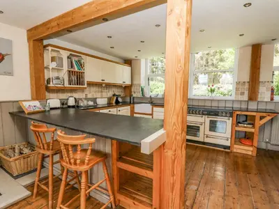 a kitchen with a large counter and wooden floors at St Marks School House in Llanwrthwl