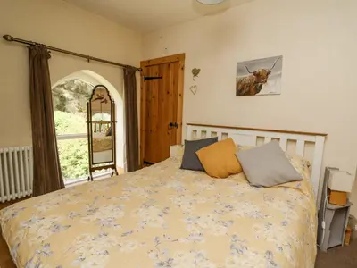a bedroom with a bed and a window at St Marks School House in Llanwrthwl