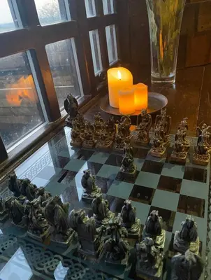 a chess board on a table with a candle at Coed Y Ddraig - themed 3 bedroom cottage, with bar & pool table in Tregaron