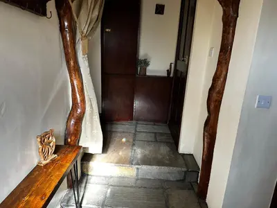 a hallway with a wooden bench in a house at Coed Y Ddraig - themed 3 bedroom cottage, with bar & pool table in Tregaron