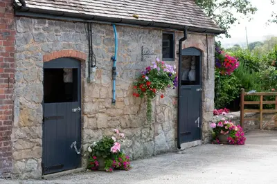 a stone building with two doors and flowers at The Caradoc in Shrewsbury