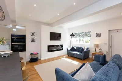 a living room with a blue couch and a fireplace at The Caradoc in Shrewsbury