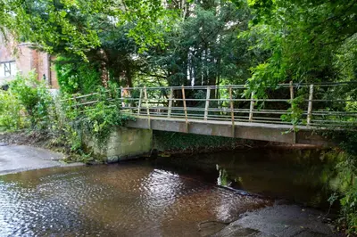 a bridge over a river with trees and water at The Caradoc in Shrewsbury