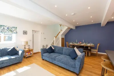 a living room with two blue couches and a table at The Caradoc in Shrewsbury