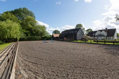 a dirt field with a wooden fence and a barn at The Caradoc in Shrewsbury