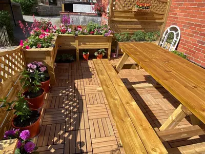 a wooden picnic table and some plants and flowers at Brooklands Guest House in Llandrindod Wells
