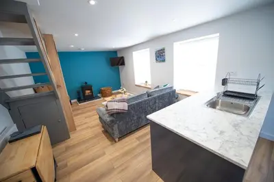 a kitchen and a living room with a couch and a table at The Old Coach House in Aberaeron