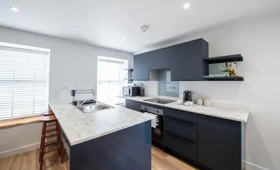 a kitchen with blue cabinets and a counter top at The Old Coach House in Aberaeron