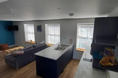 a kitchen and living room with a couch and a table at The Old Coach House in Aberaeron