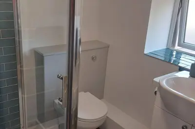 a white bathroom with a toilet and a sink at The Old Coach House in Aberaeron